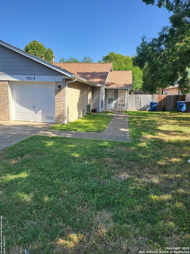 single story home featuring fence, an attached garage, a front yard, and brick siding