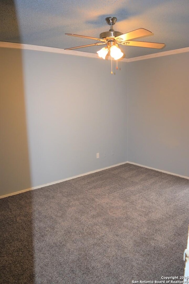 carpeted empty room with crown molding, baseboards, and ceiling fan