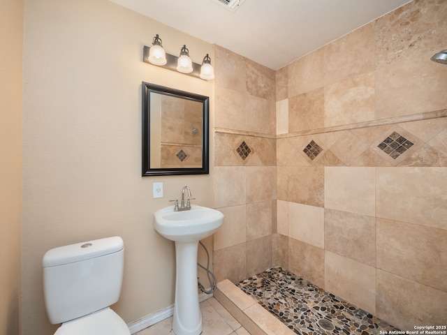 1136 Kentucky Ave, San Antonio, TX 78201 - full bathroom with tile patterned flooring, a tile shower, and toilet