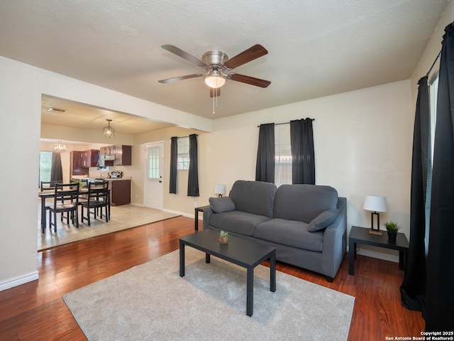1136 Kentucky Ave, San Antonio, TX 78201 - living room featuring baseboards, ceiling fan with notable chandelier, wood finished floors, and visible vents