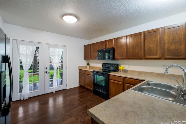 kitchen with french doors, a textured ceiling, dark wood finished floors, a sink, and black appliances