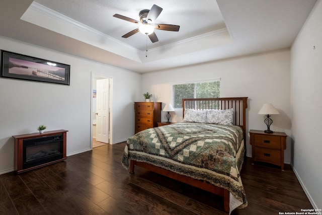 bedroom featuring crown molding, a raised ceiling, baseboards, and wood finished floors