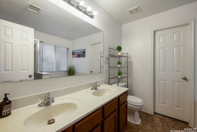 bathroom featuring a sink, toilet, and visible vents