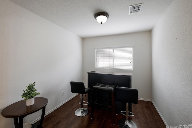 office space with visible vents, baseboards, and wood finished floors
