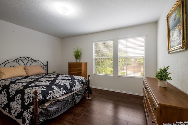 bedroom featuring dark wood-style flooring, baseboards, and a textured ceiling