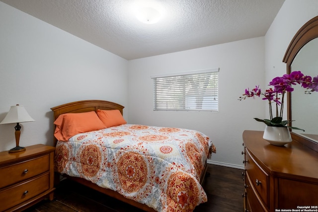 bedroom featuring baseboards, dark wood-style floors, and a textured ceiling