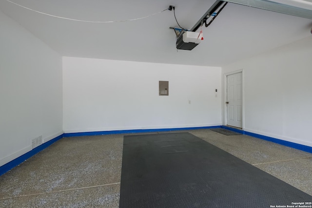garage with electric panel, baseboards, a garage door opener, and visible vents