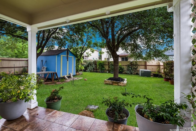 view of yard featuring a storage shed, an outdoor structure, and a fenced backyard