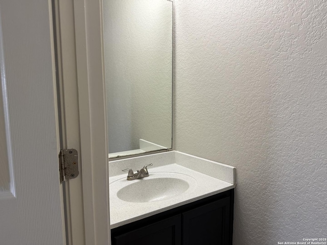 bathroom featuring a textured wall and vanity