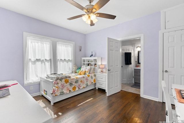 bedroom with baseboards, connected bathroom, ceiling fan, and dark wood-style floors