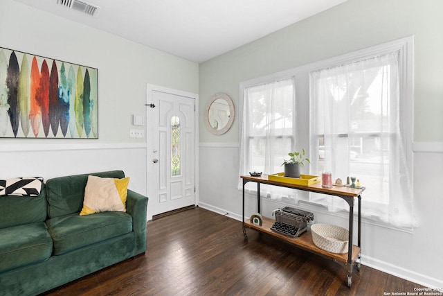 foyer entrance featuring visible vents, baseboards, and wood finished floors