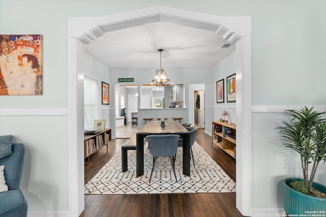 dining space featuring visible vents, dark wood-style flooring, and a notable chandelier
