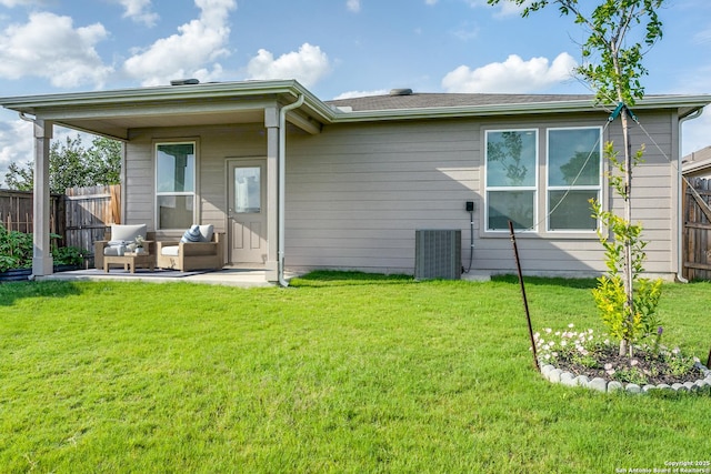 back of property featuring fence, a patio, a yard, and cooling unit