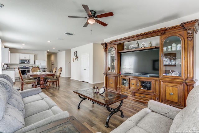 living room featuring ceiling fan, recessed lighting, baseboards, wood finished floors, and visible vents