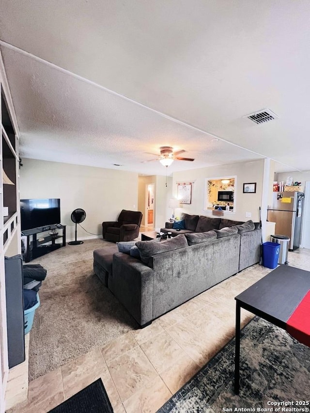 living room featuring visible vents and ceiling fan