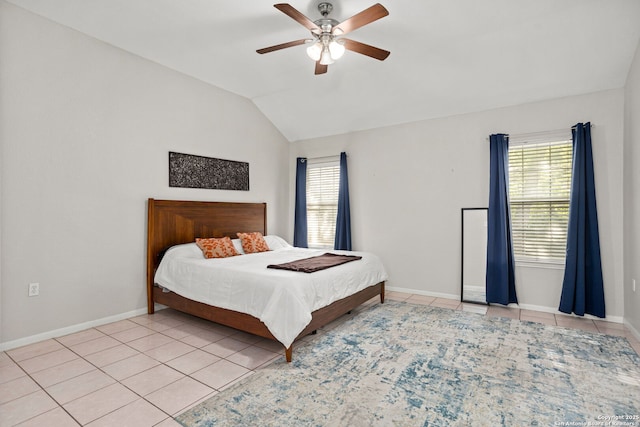 bedroom with light tile patterned floors, baseboards, multiple windows, and vaulted ceiling