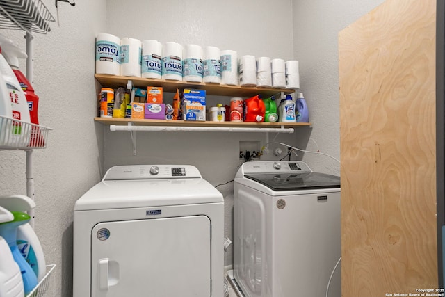 laundry room featuring separate washer and dryer, a textured wall, and laundry area
