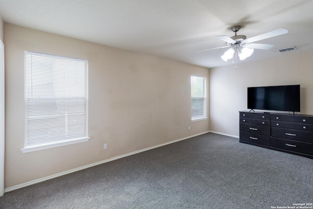 unfurnished bedroom featuring dark carpet, a ceiling fan, baseboards, and visible vents