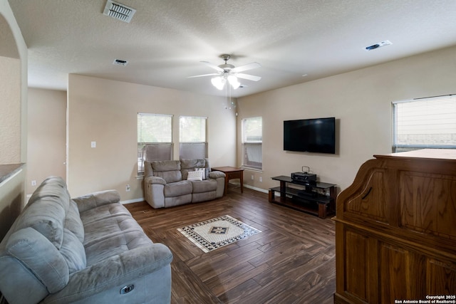 living area with plenty of natural light, baseboards, ceiling fan, and visible vents