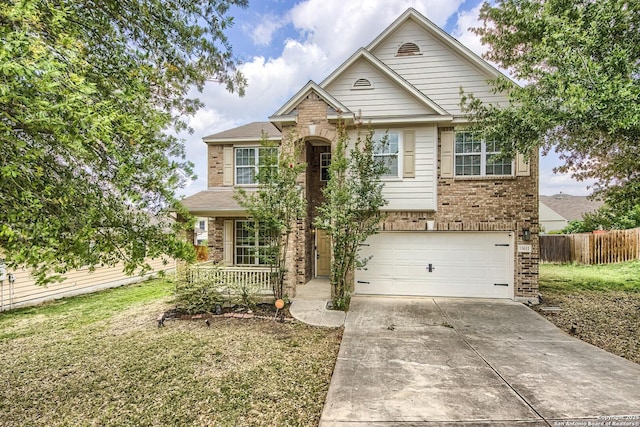 traditional-style house with a front lawn, fence, brick siding, an attached garage, and driveway