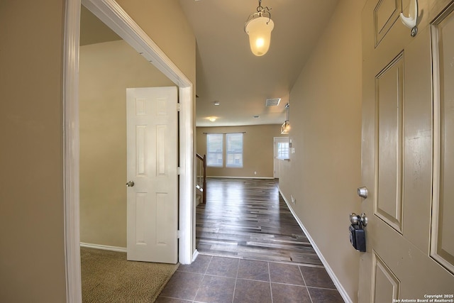foyer featuring dark tile patterned floors, baseboards, and visible vents