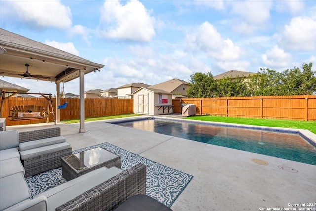 view of pool featuring a fenced backyard, outdoor lounge area, a patio area, and a shed