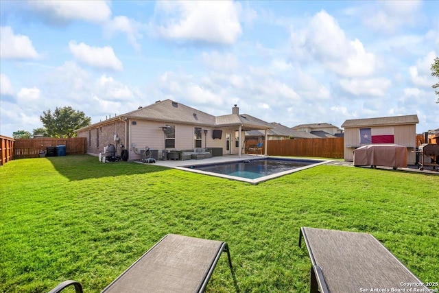 back of property with a lawn, a patio, a fenced in pool, and a fenced backyard