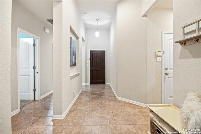 hallway with light tile patterned flooring and baseboards
