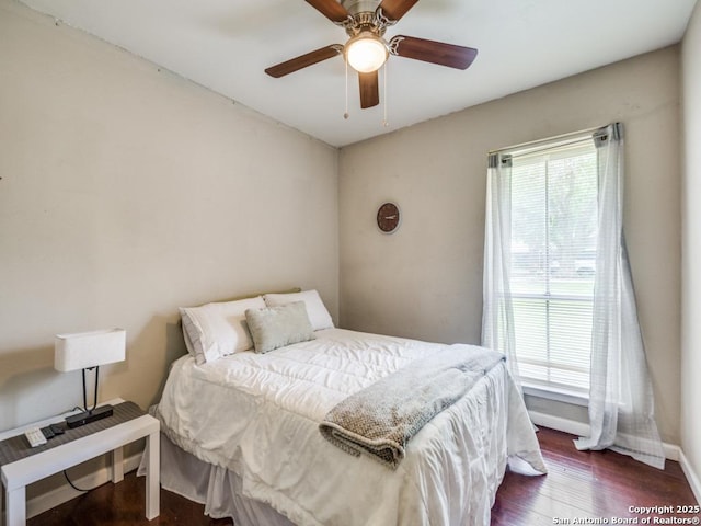bedroom featuring dark wood-type flooring, baseboards, and ceiling fan