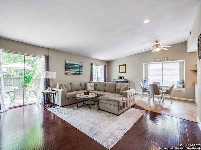 living area with a ceiling fan, baseboards, dark wood finished floors, and vaulted ceiling