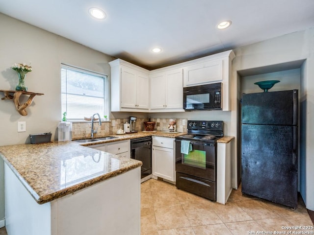 kitchen with light stone counters, a sink, white cabinetry, a peninsula, and black appliances