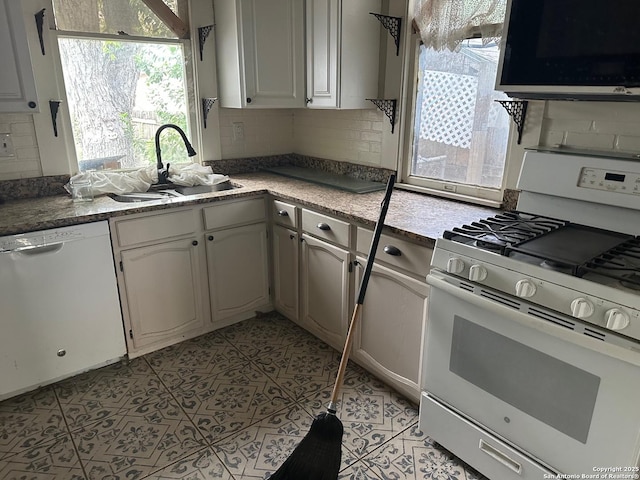 kitchen with a sink, white appliances, and tasteful backsplash