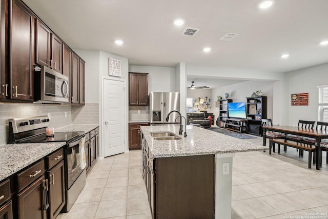9223 Yaya, Converse, TX 78109 - kitchen featuring dark brown cabinets, appliances with stainless steel finishes, a sink, an island with sink, and visible vents