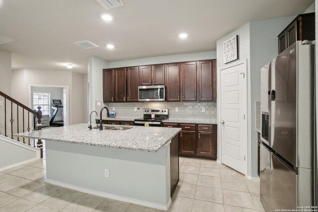 9223 Yaya, Converse, TX 78109 - kitchen with dark brown cabinetry, light tile patterned floors, a sink, appliances with stainless steel finishes, and backsplash