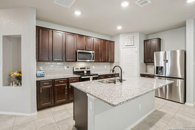 9223 Yaya, Converse, TX 78109 - kitchen with dark brown cabinets, appliances with stainless steel finishes, a sink, decorative backsplash, and visible vents