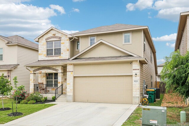 9223 Yaya, Converse, TX 78109 - traditional-style house featuring a porch, roof with shingles, concrete driveway, stone siding, and stucco siding