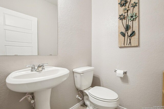 9223 Yaya, Converse, TX 78109 - half bath featuring baseboards, a sink, and toilet