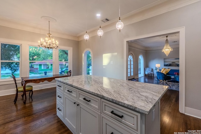 kitchen with a chandelier, dark wood-type flooring, light stone counters, ornamental molding, and baseboards