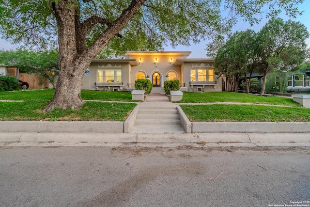 view of front of property with stucco siding and a front yard