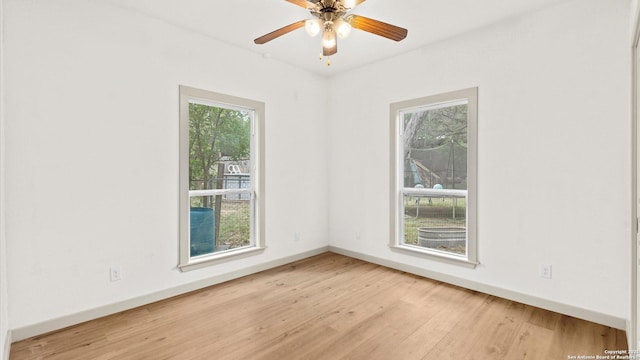 spare room featuring baseboards, ceiling fan, and wood finished floors