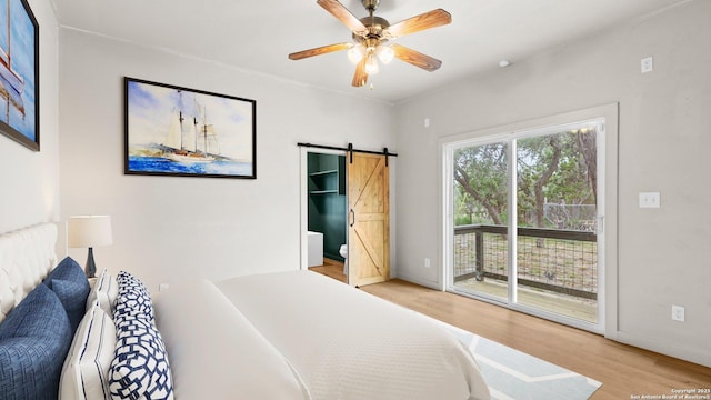 bedroom with access to exterior, baseboards, a barn door, a ceiling fan, and light wood finished floors