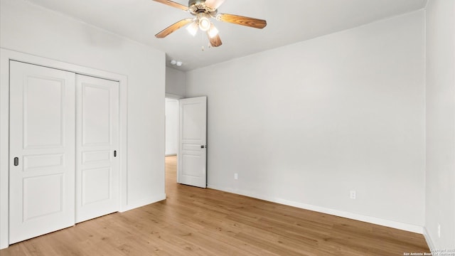 unfurnished bedroom featuring a closet, baseboards, a ceiling fan, and light wood-type flooring