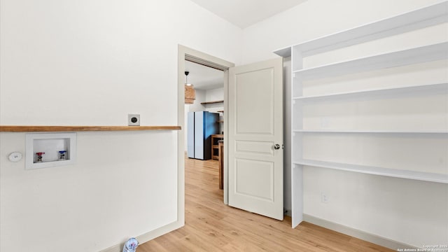 washroom featuring laundry area, baseboards, hookup for a washing machine, electric dryer hookup, and light wood finished floors
