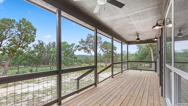 unfurnished sunroom with ceiling fan