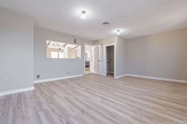 2902 Big Horn, San Antonio, TX 78228 - spare room featuring light wood finished floors, baseboards, and a textured ceiling