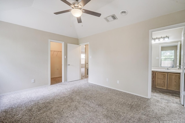 unfurnished bedroom featuring a spacious closet, baseboards, light colored carpet, and visible vents