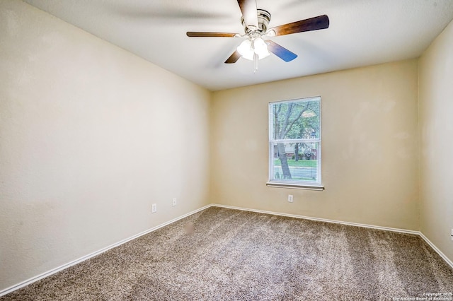 carpeted spare room featuring baseboards and a ceiling fan