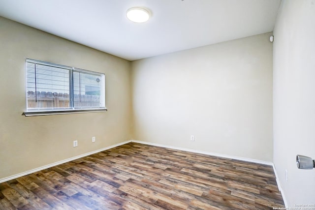 empty room with baseboards and wood finished floors