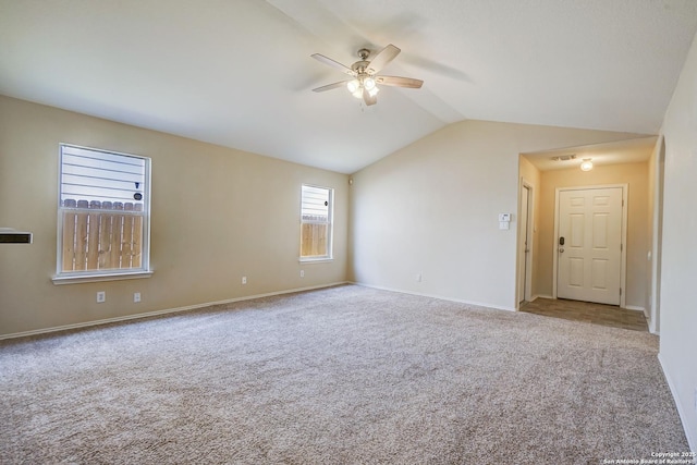 carpeted empty room featuring baseboards, ceiling fan, visible vents, and lofted ceiling