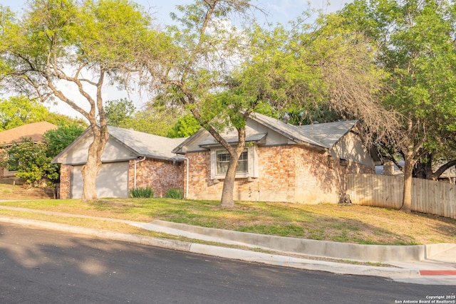 ranch-style house with fence, a front lawn, and brick siding